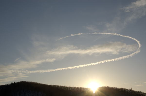 嵐が去ろうとしている夕暮れ時、空に大きな丸が描かれていました。これは飛行機雲でしょうか。