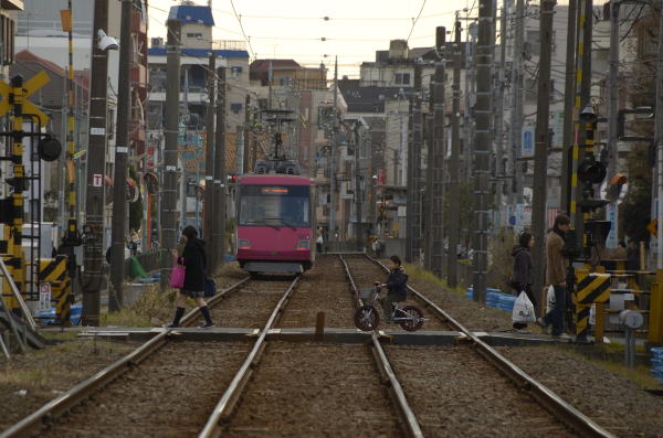 冬の午後。世田谷線の踏切を渡る人たち。何気ない日常の風景です。