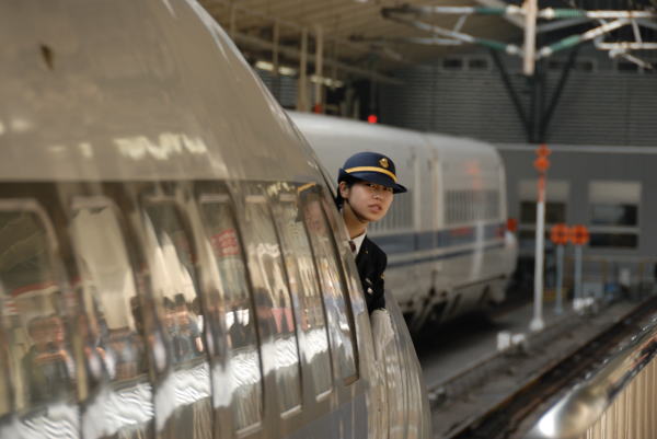 東京駅を発車する500系のぞみにカメラを向けたら、たまたま女性乗務員が顔を出していました。まだとても若いこの車掌さんにとっても長い旅の始まりです。
